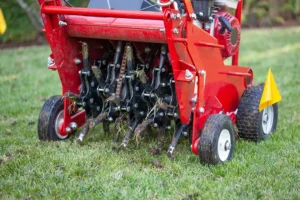 Core aeration machine removing soil plugs during professional lawn aeration in Omaha, NE to improve turf health and reduce soil compaction.