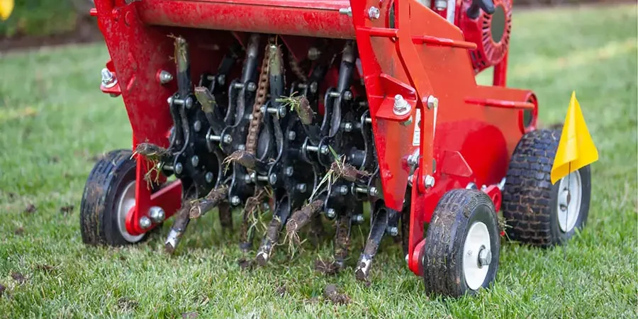 Core aeration machine removing soil plugs during professional lawn aeration in Omaha, NE to improve turf health and reduce soil compaction.